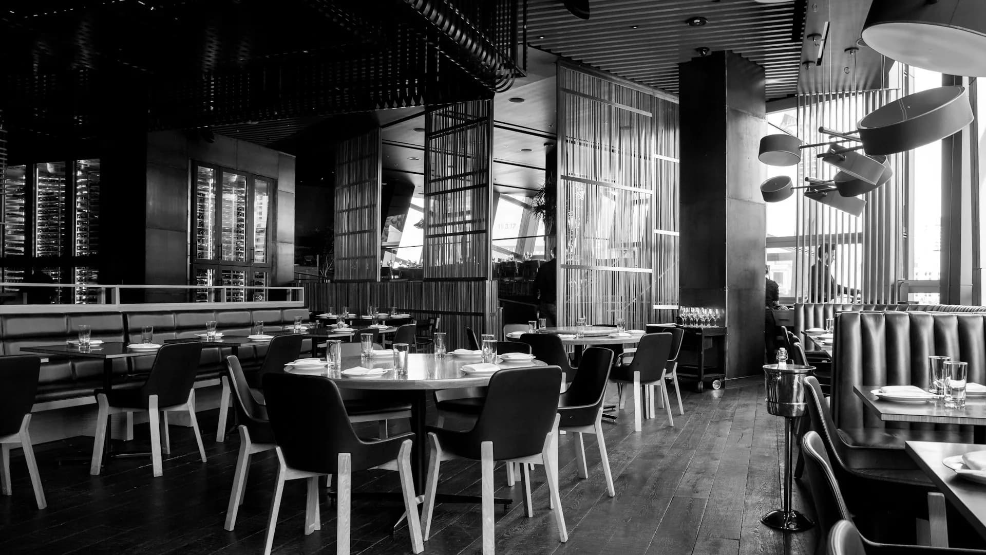 Ein warm beleuchteter Restaurant-Gastraum, für den Service eingedeckt
